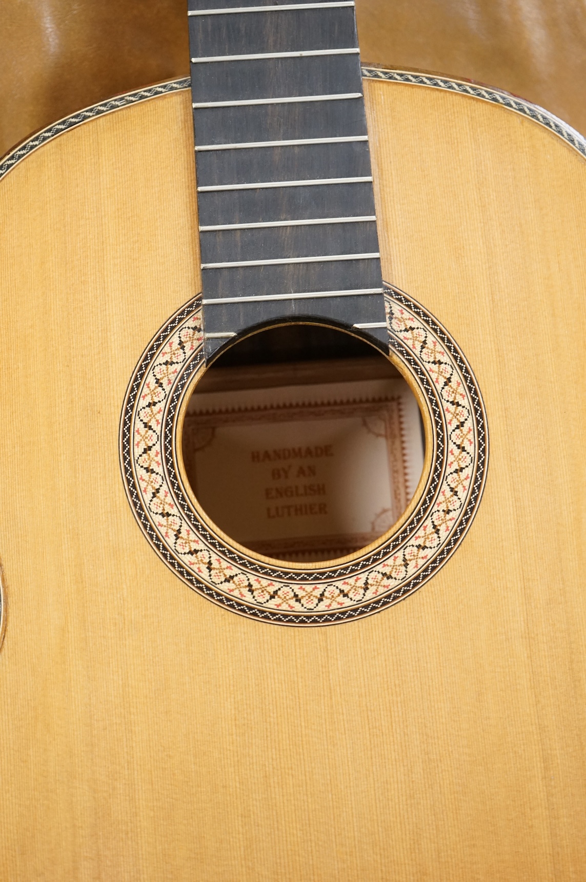 A handmade cedar, Indian Rosewood and ebony classical guitar by 'an English Luthier', with label to the inside of the body, together with a soft case.